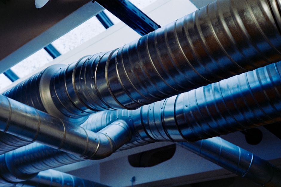 Unidad de recuperación de calor con sus conductos de impulsión y extracción instalada en un falso techo